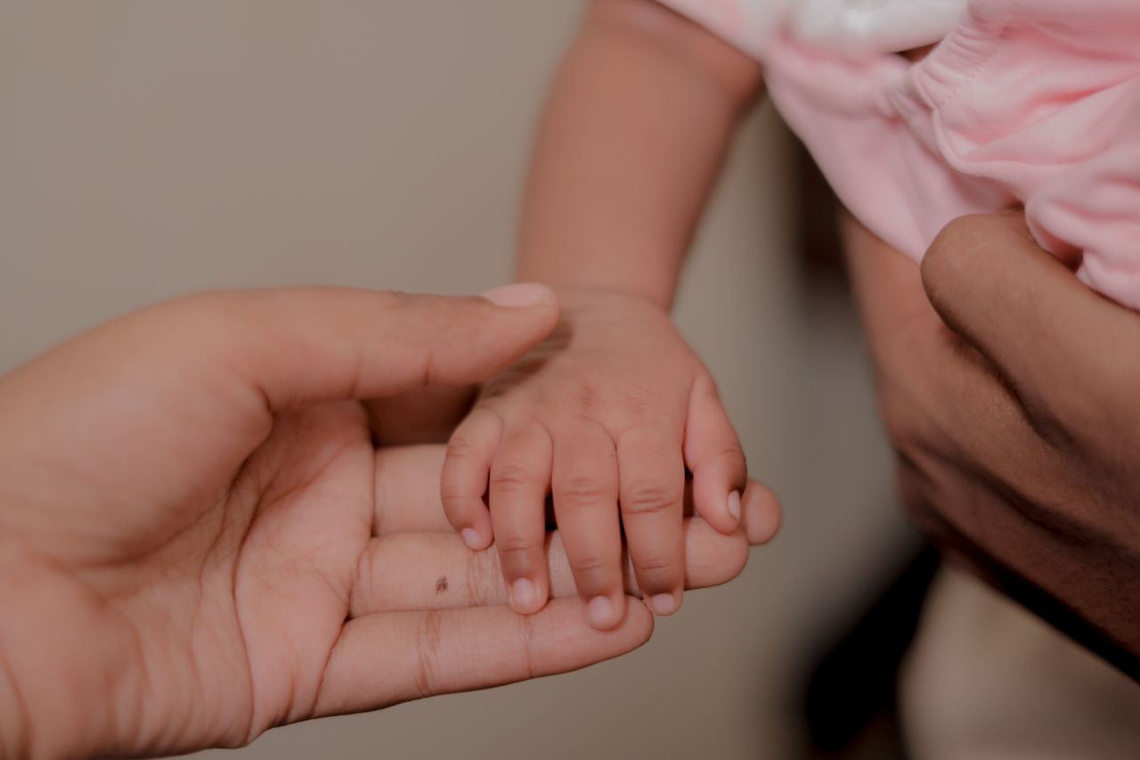 Capturing the tender connection between a baby and parent through a simple hand hold.